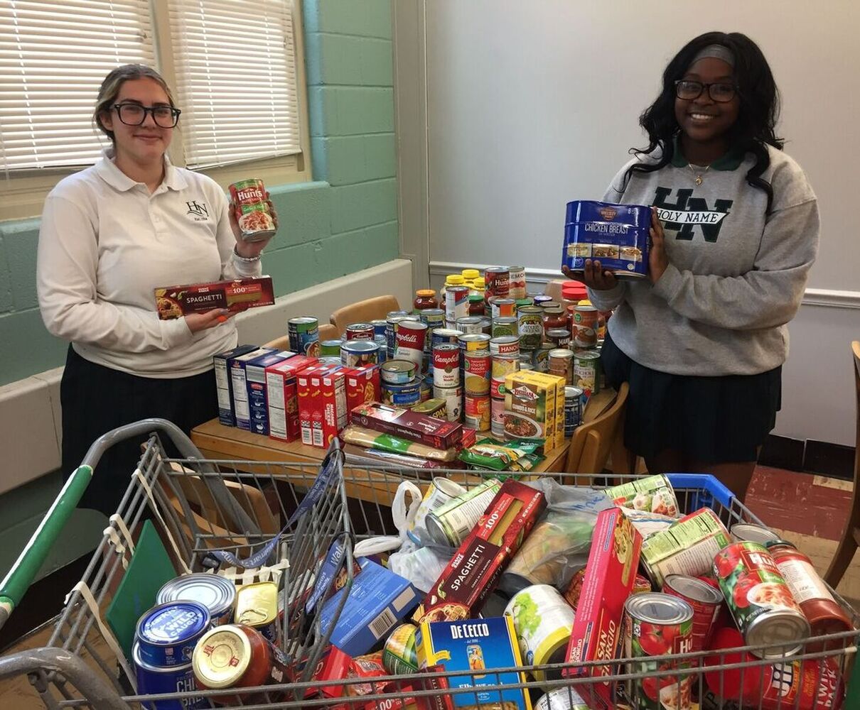 2 girls with shopping cart full for food pantry